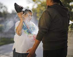 Curandera cleansing a person using smoke and a feather to spread the smoke.