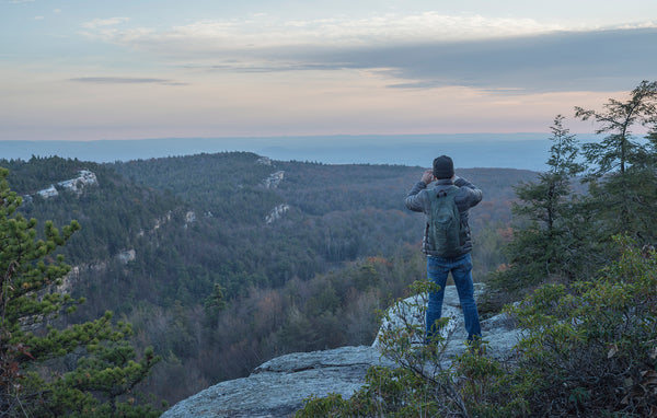 a hiker looking out over the hudson valley from a cliff edge in Minnewaska State Park