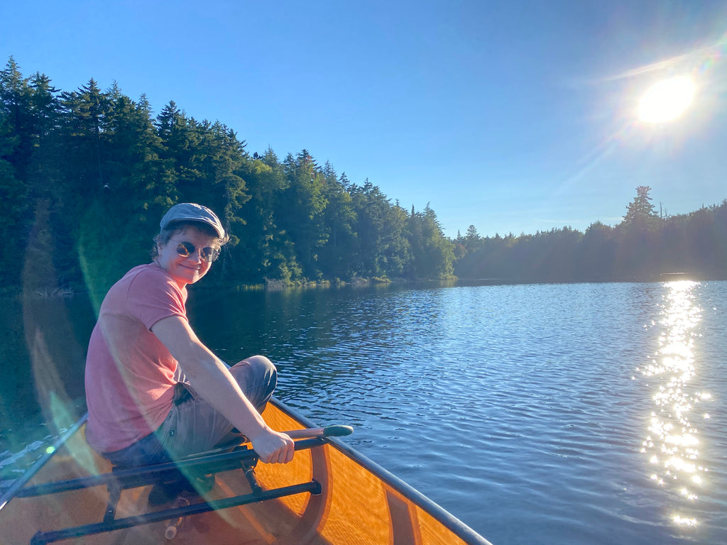 a person in the front of a canoe with a lake in the background