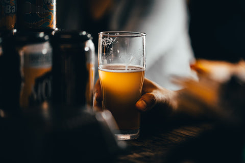 a hand holding a glass of beer