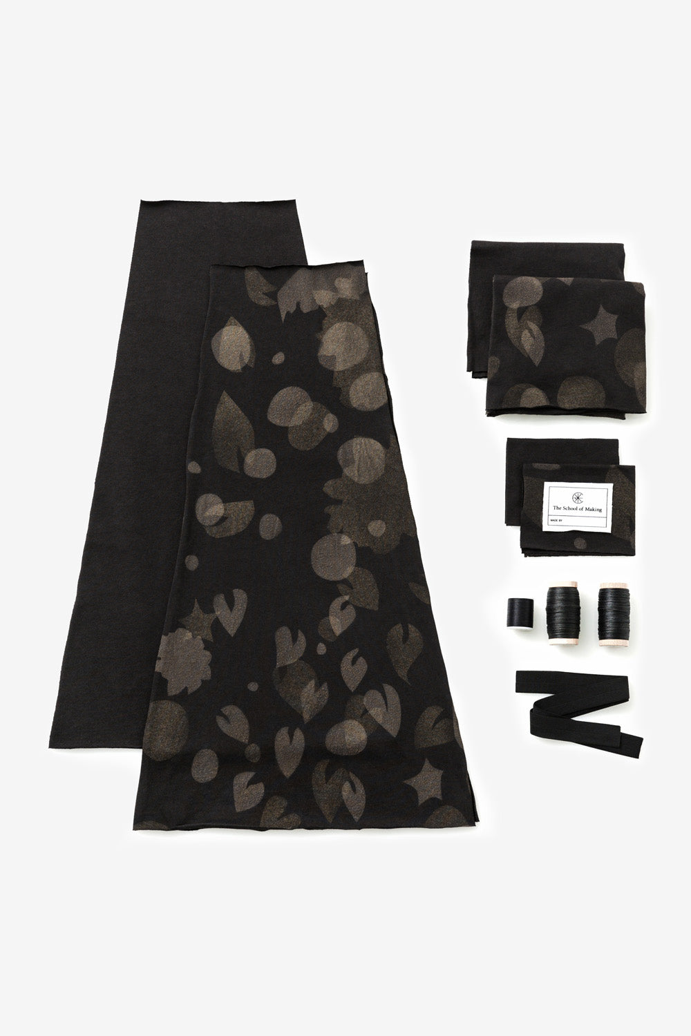 The School of Making Embroidered Swing Skirt Kit in Black with Canopy Stencil. Image shows hand-cut fabric pieces, thread, embroidery floss, binding, and a label.