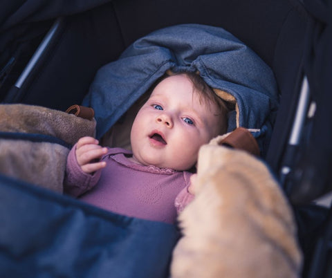 Baby ligger i barnevogn og har øjenkontakt