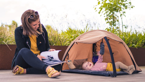 Baby, der ligger på Sleepbag aktivitetstæppe med UV-cover, som beskytter mod overstimulering