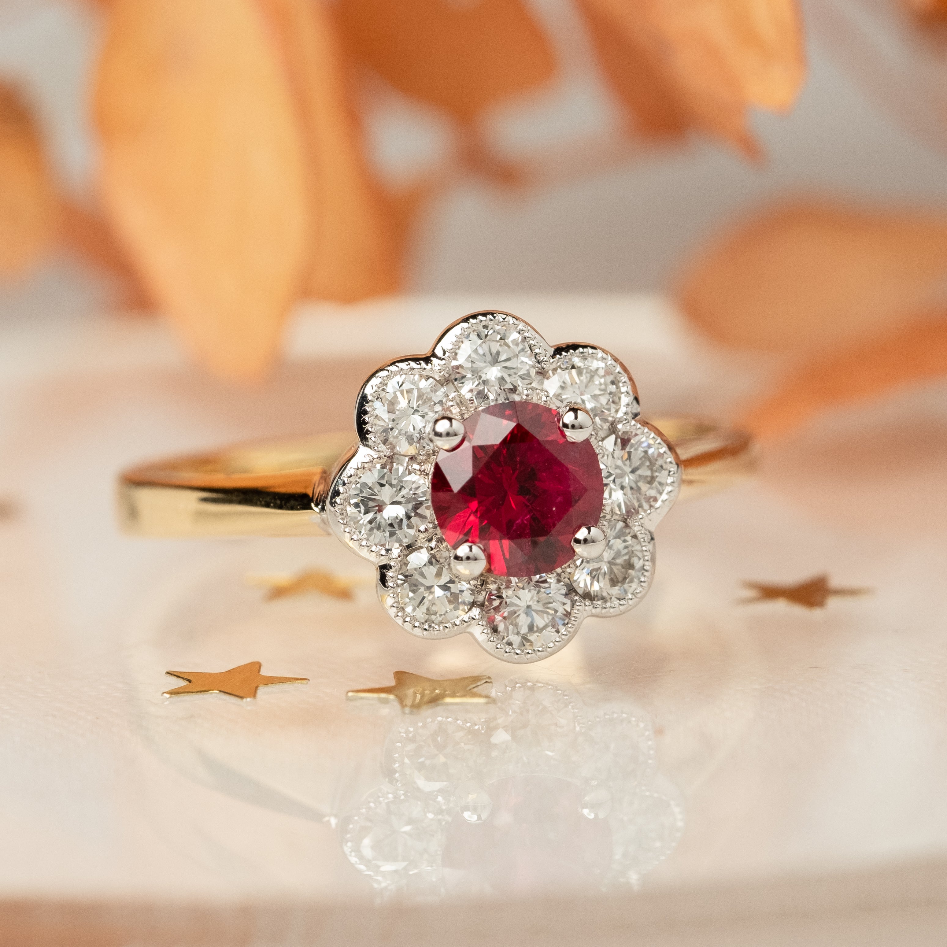 Vintage style ring with a ruby surrounded by a diamond daisy cluster