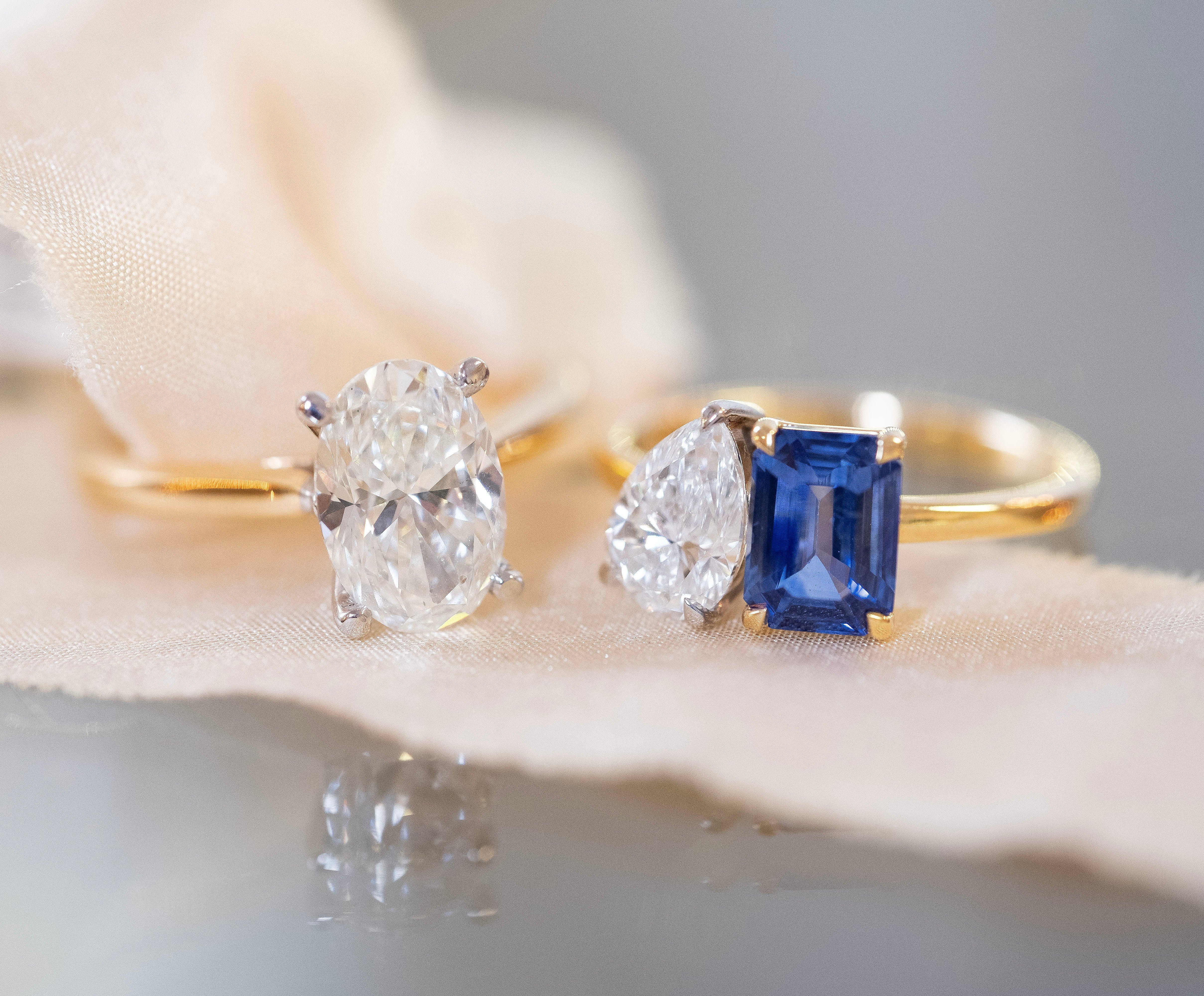 An oval solitaire engagement ring and a Toi et Moi sapphire and diamond engagement ring