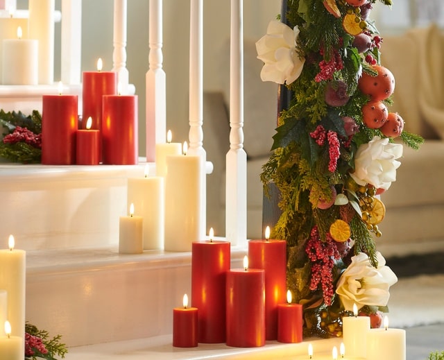 Raz Imports Battery Candles on Staircase With Red and Ivory Lush Natural Garland on Stair Rail