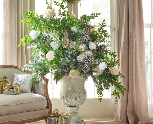Raz Imports Elegant Winter Holiday Silk Arrangement In Large Urn With Draping Greenery Frosted Pinecones and White Roses