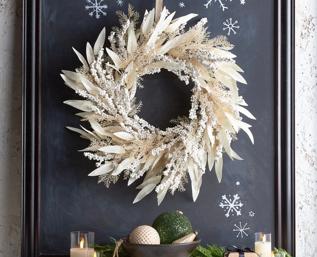 Raz Imports Winter White Christmas Wreath On Dark Wall With Snowflakes and Emerald Green Christmas Ornament 