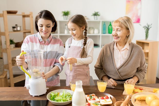 Three women making a smoothie