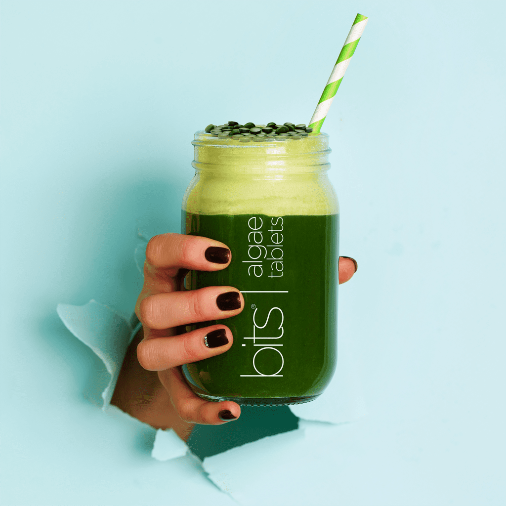 hand holding green smoothie with algae 