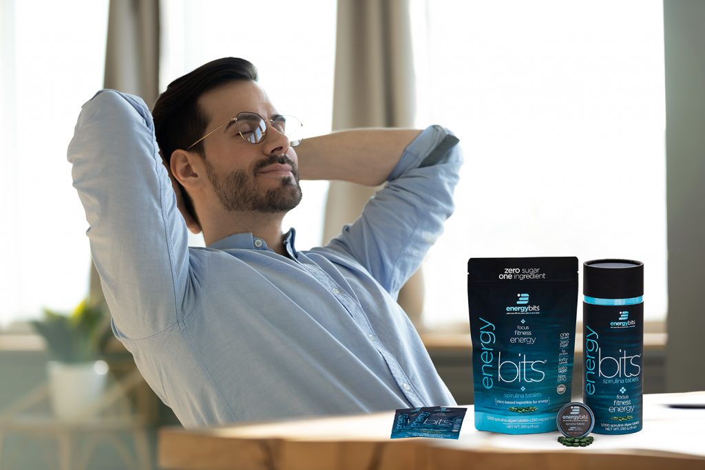 man relaxing at desk with algae 