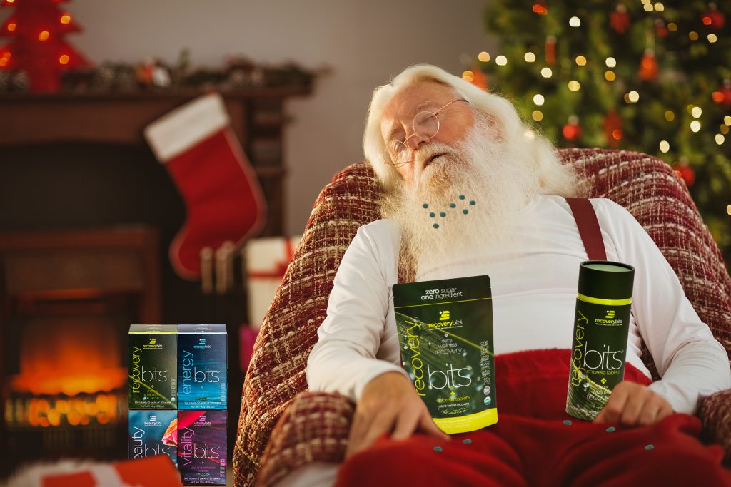 Santa Clause sleeping in chair with ENERGYbits products in lap. 