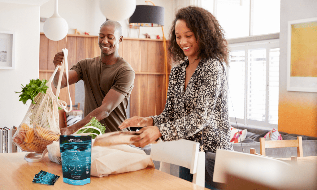 Couple unpacking their groceries with an ENERGYbits bag on the table