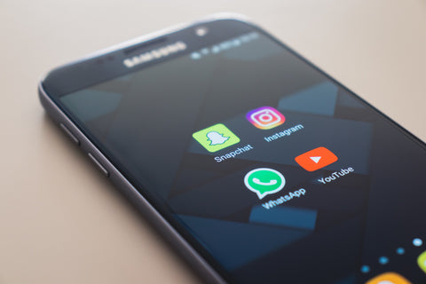A phone with social media apps open on the screen