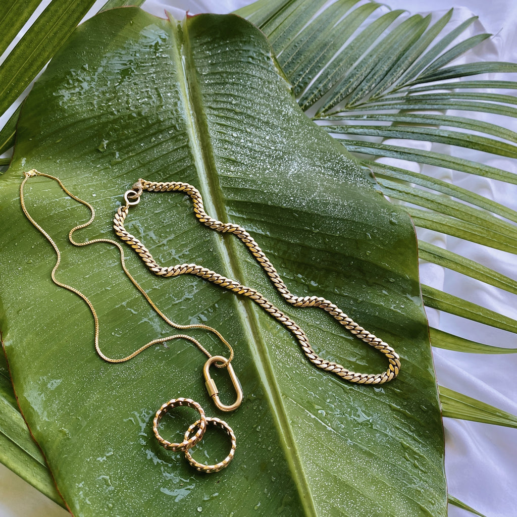 solid gold jewelry on green palm leaf