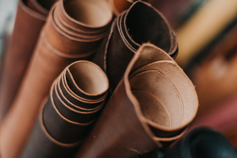 rolled kangaroo leather in different colours all stacked on top of each others to be made into belts, wallest or hatbands.