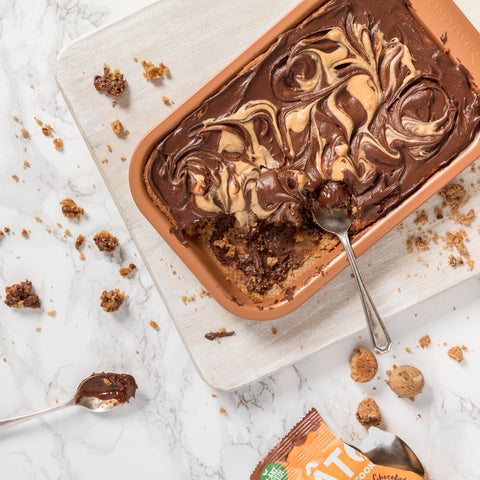 chocolate and peanut butter tray with open packet of cookies on a board with a spoon