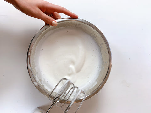 whipped aquafaba and hand and whisk