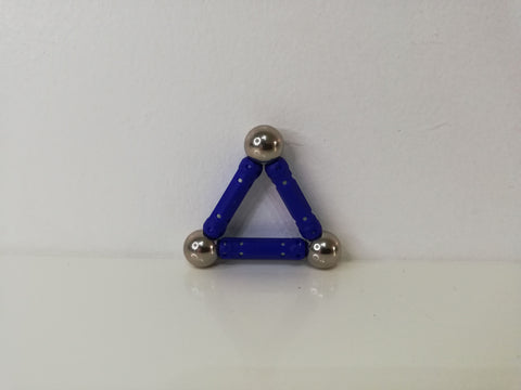 triangle en bâtonnets magnétiques sur un mur blanc