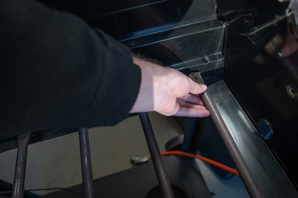 person removing a gas grill burner
