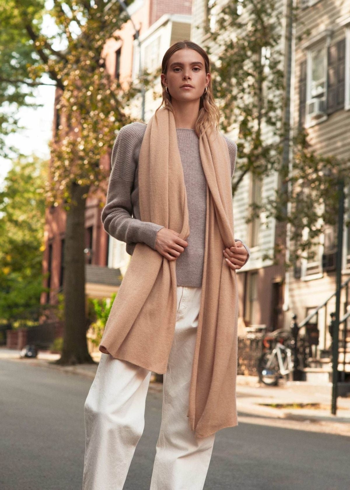 woman wearing the camel color cashmere travel wrap by white + warren