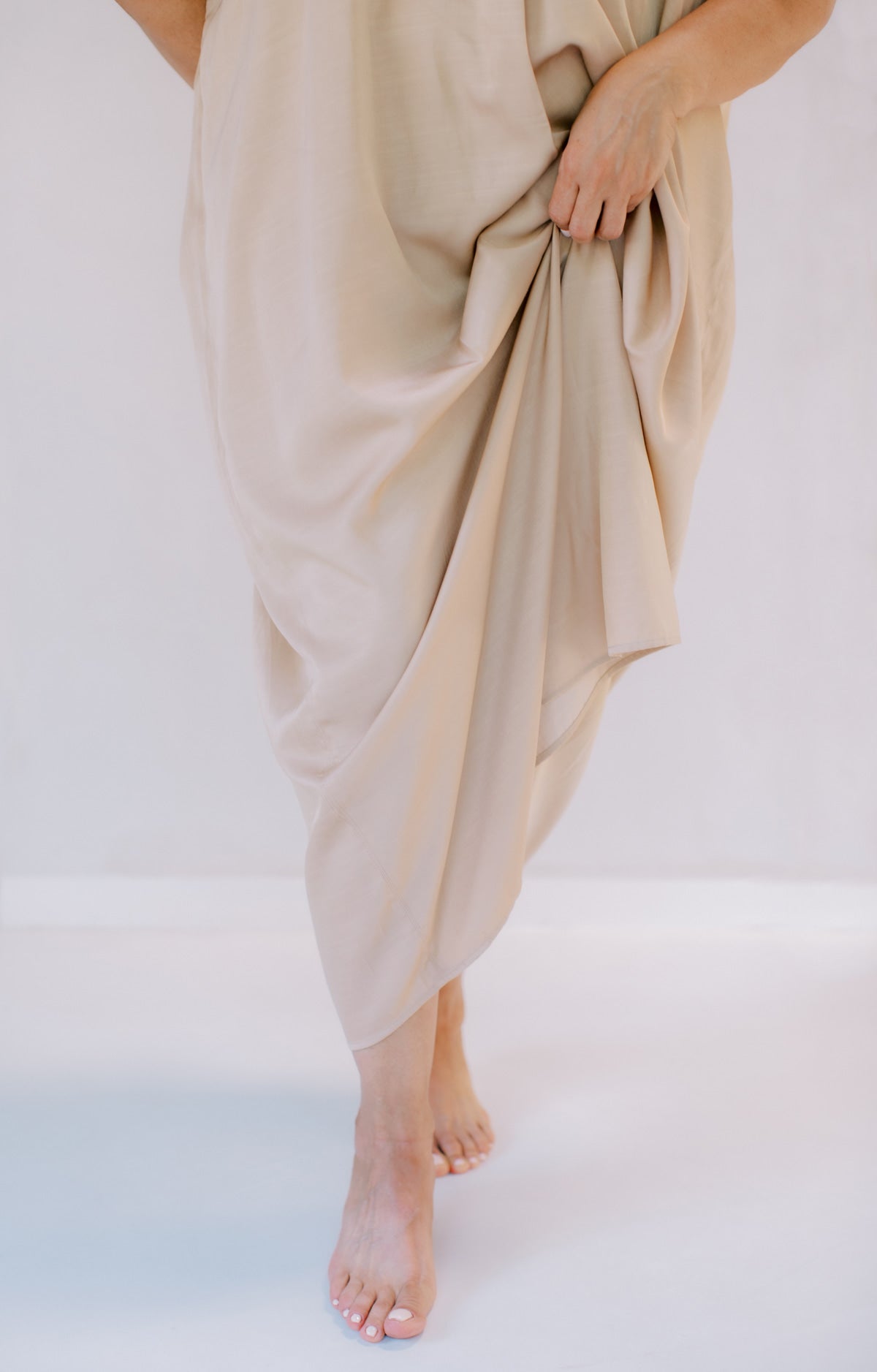 woman wearing a beige flowy dress on the beach