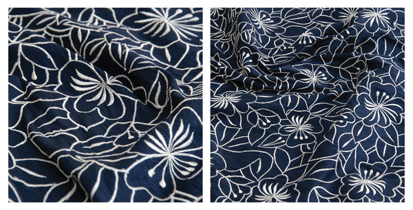 Wrinkled navy embroidery silk fabric with white floral motifs over a navy background, ideal for statement party looks or even luxurious homeware.