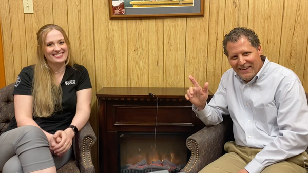 Megan Berry, Klein Tools Rep and Danny Matthews, President J.L. Matthews sitting by a fireplace.