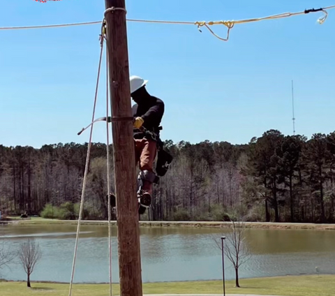 Jimmy Brown climbing a utility pole