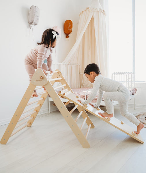 girl and boy climbing on the montessori pikler triangle by piccalio