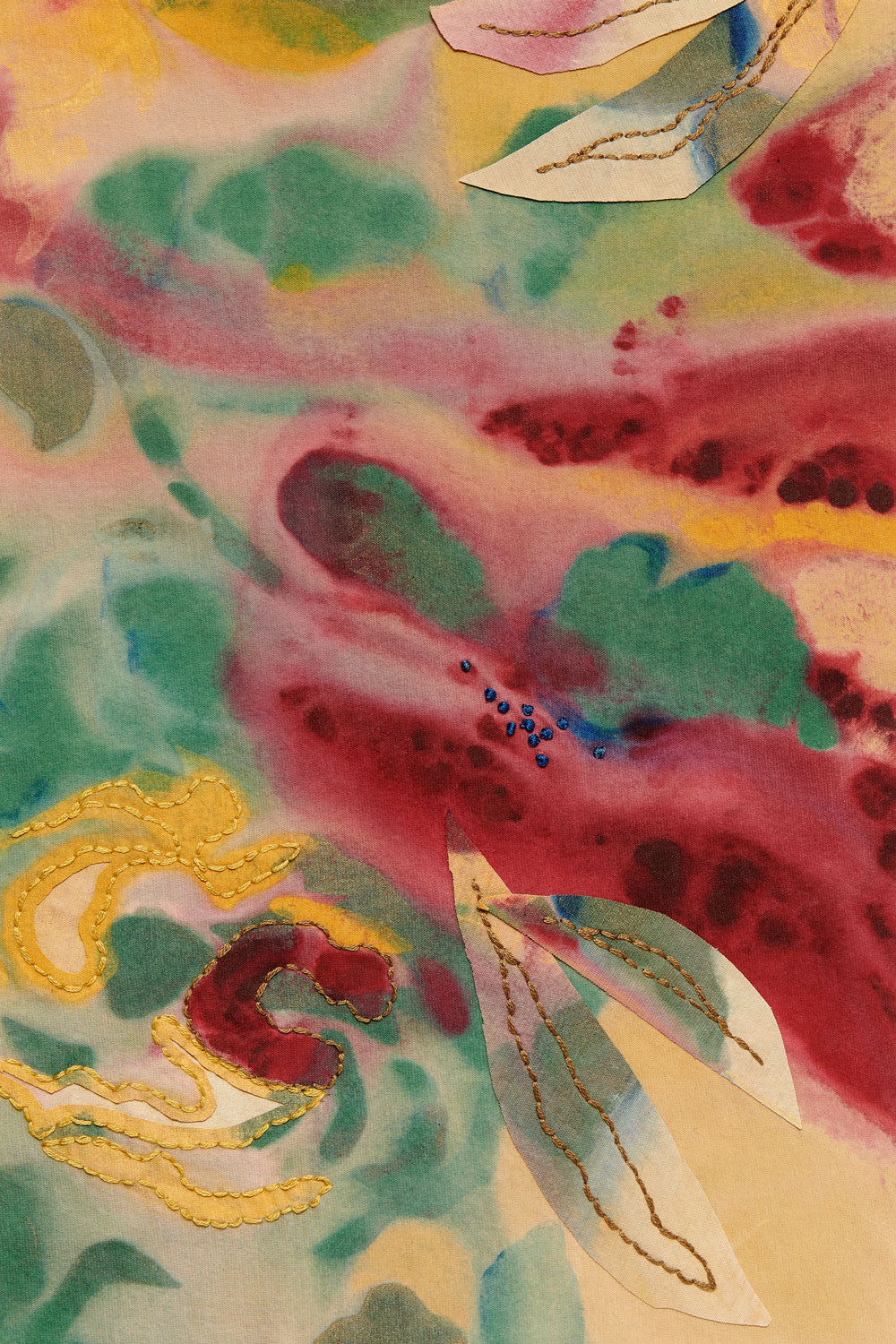 Detail of the Loulou design featuring yellow, red, green, and blue paint along with floral appliqué and embroidery.