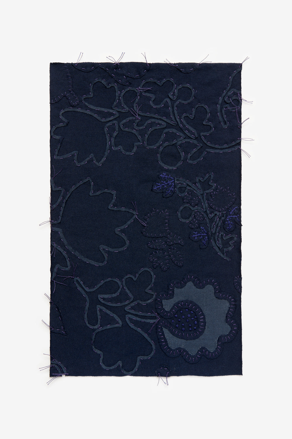 Swatch featuring hand-sewn floral appliqué and embroidery on navy fabric.