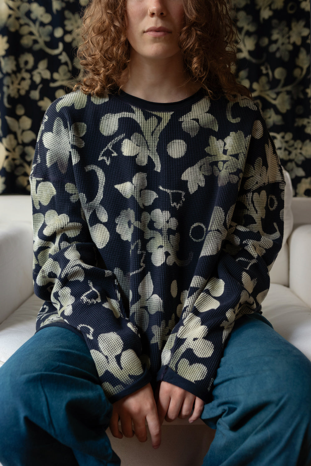 Model wearing the Merritt Top, a navy waffle crew top with hand-painted flowers.