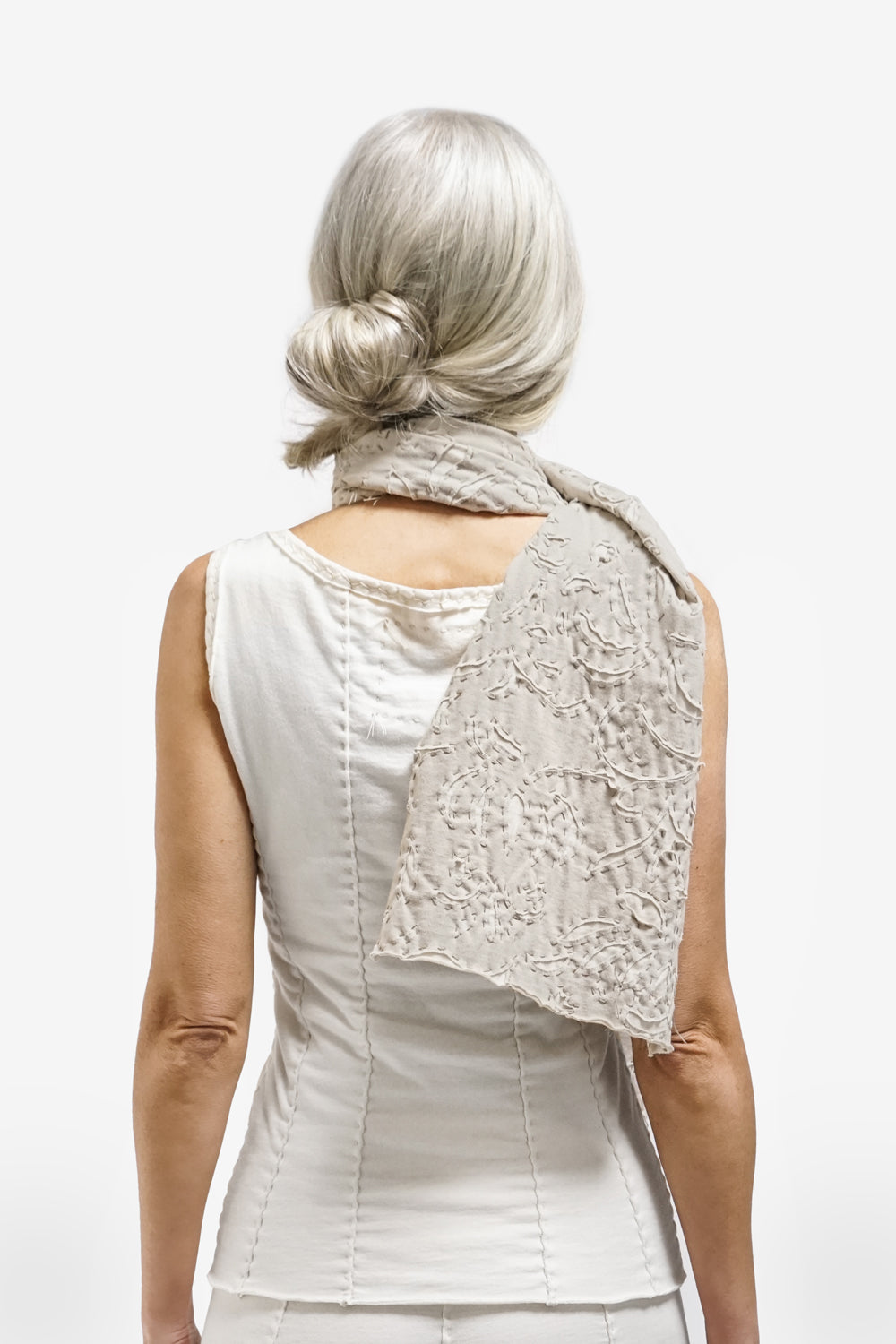 Model wearing the scarf in sand and natural, with Anna's Garden reverse appliqué.