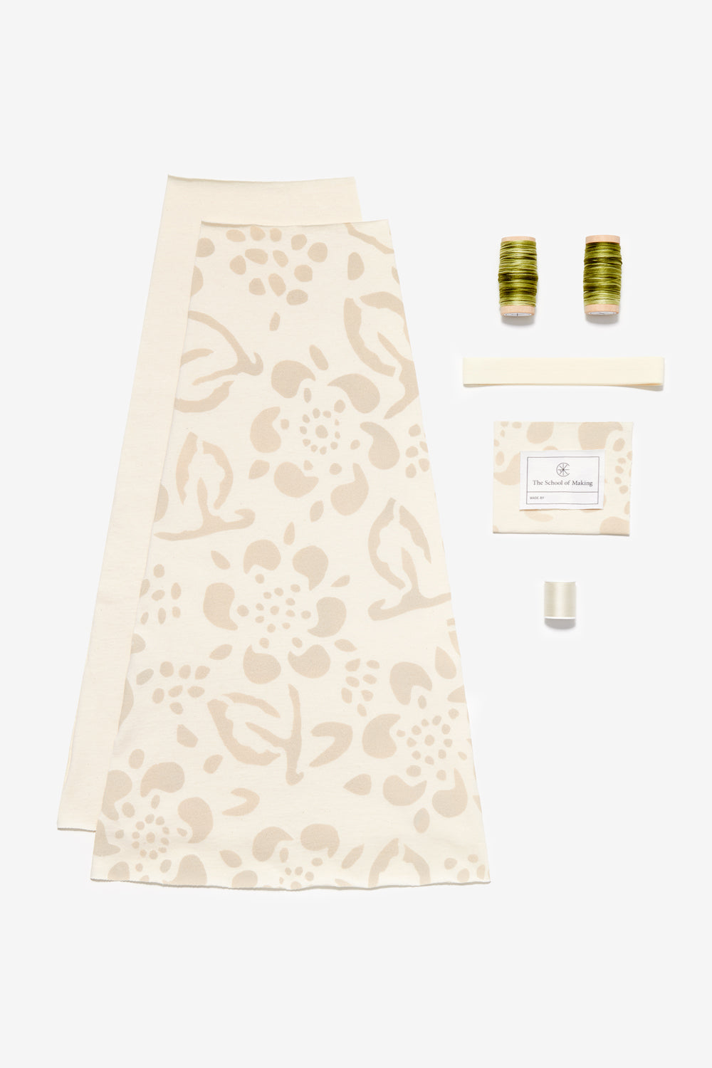 Kit contents of the Swing Skirt in Natural with Daisy stencil and green embroidery floss.
