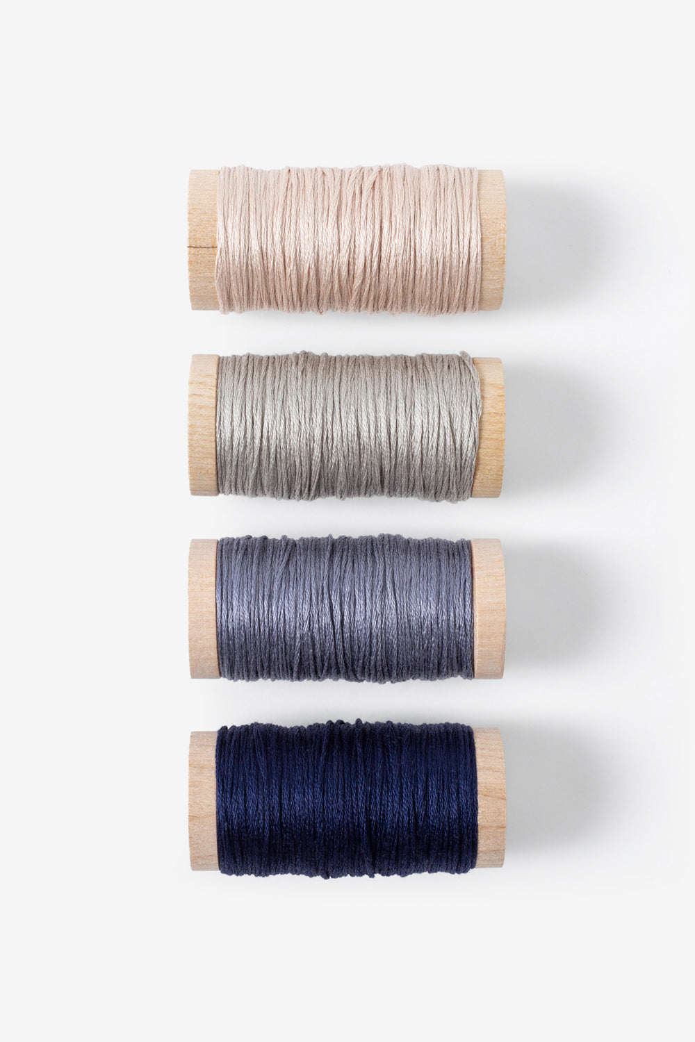 The School of Making Embroidery Floss Bundle in soft tan, light gray, slate blue, and navy blue colors.