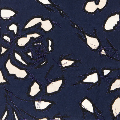Reverse appliqué fabric swatch in navy on natural and beige