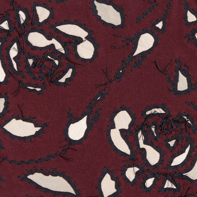 Reverse appliqué fabric swatch in plum on natural and sand