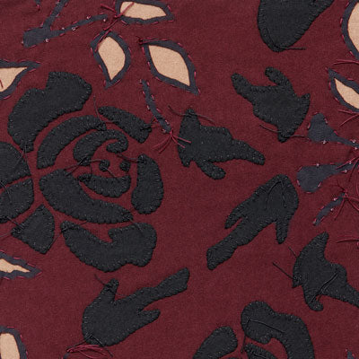 Fabric swatch with black, plum, and vetiver appliqué