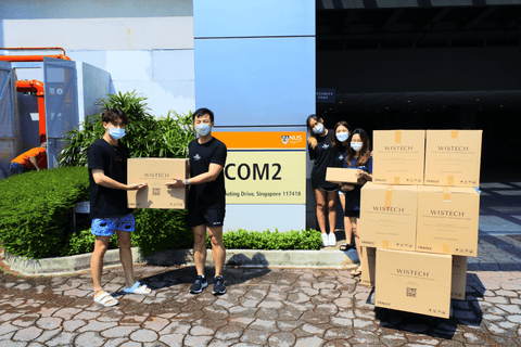 Photograph taken in front of NUS Business School with Wistech mask boxes and Shiora box