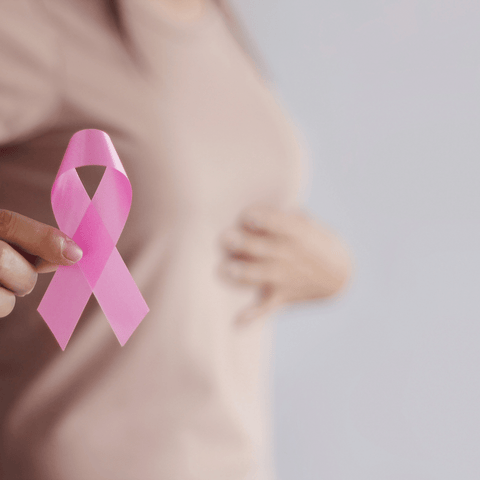 women carrying a pink ribbon