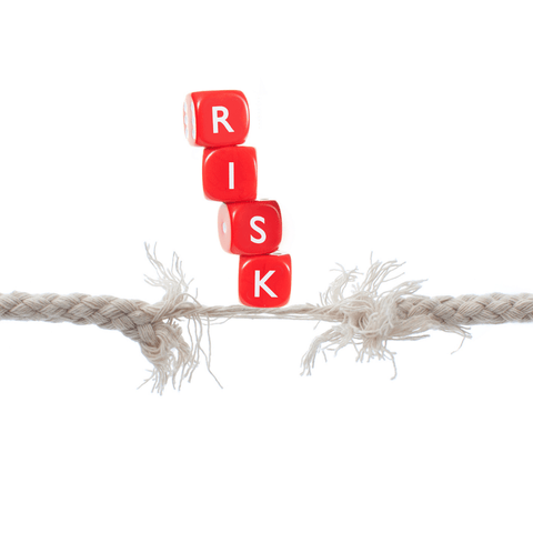 4 dice that says RISK on top of a broken rope 