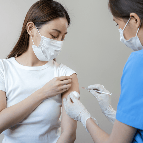 a female nurse treating a female wearing medical masks