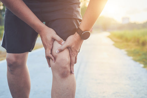 El hombre toca su rodilla izquierda lesionada.