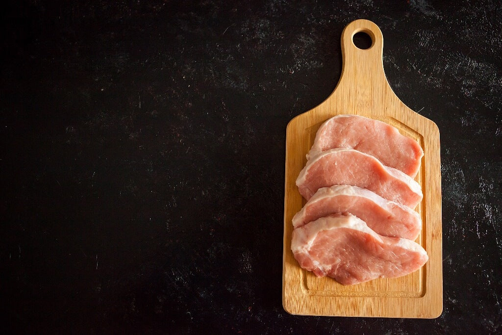 Pork Chops Arranged On Chopping Board