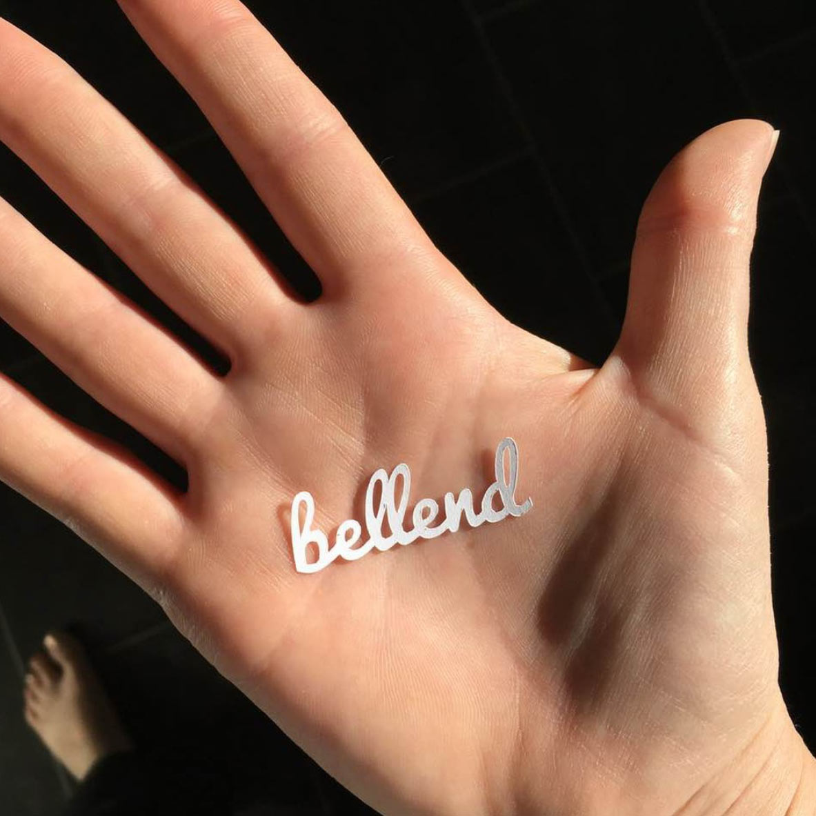 An open hand with a tiny bit of confetti in it. The confetti reads "bellend"