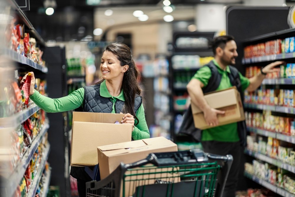 supermarket employees adding products to shelves