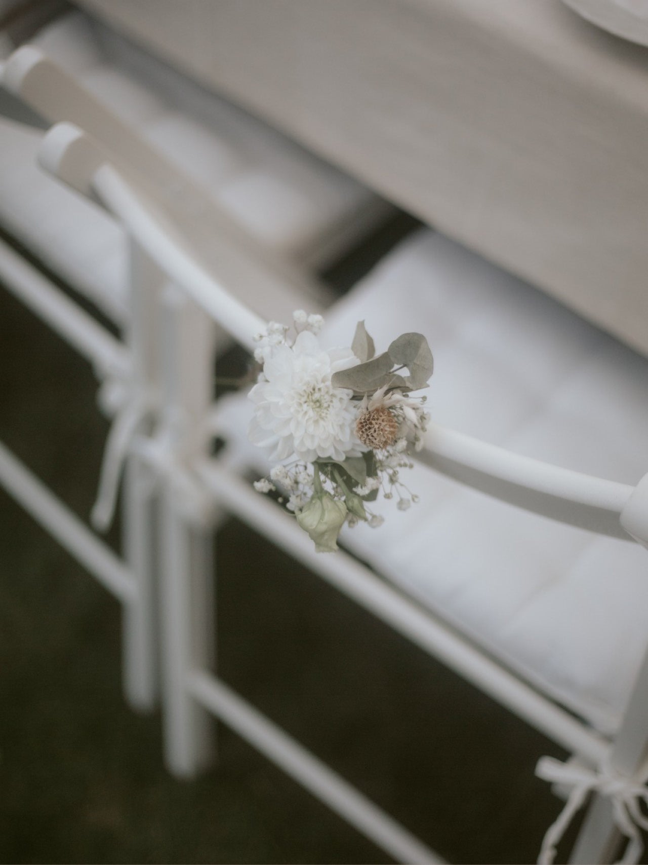 Weiße Klappstühle dekoriert mit einer kleinen Blume