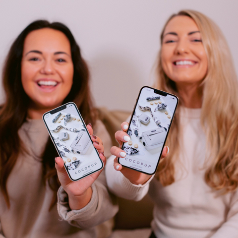 Founders holding phone with cocopup app