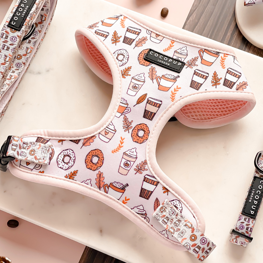 Pink dog harness with coffee cup and donut patterns.